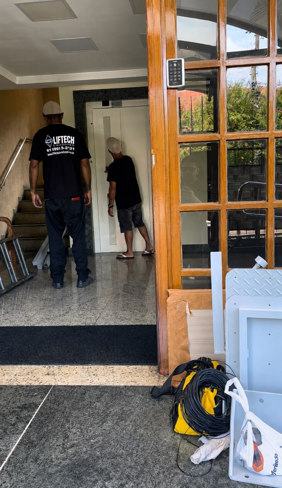 Equipe da Liftech Elevadores em atendimento no hall de entrada de um edifício